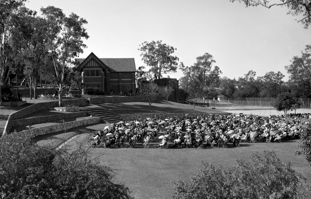Spectators seated and facing a small podium on the Flat prior to an event at the Anglican Church Grammar School, East Brisbane, October 1969