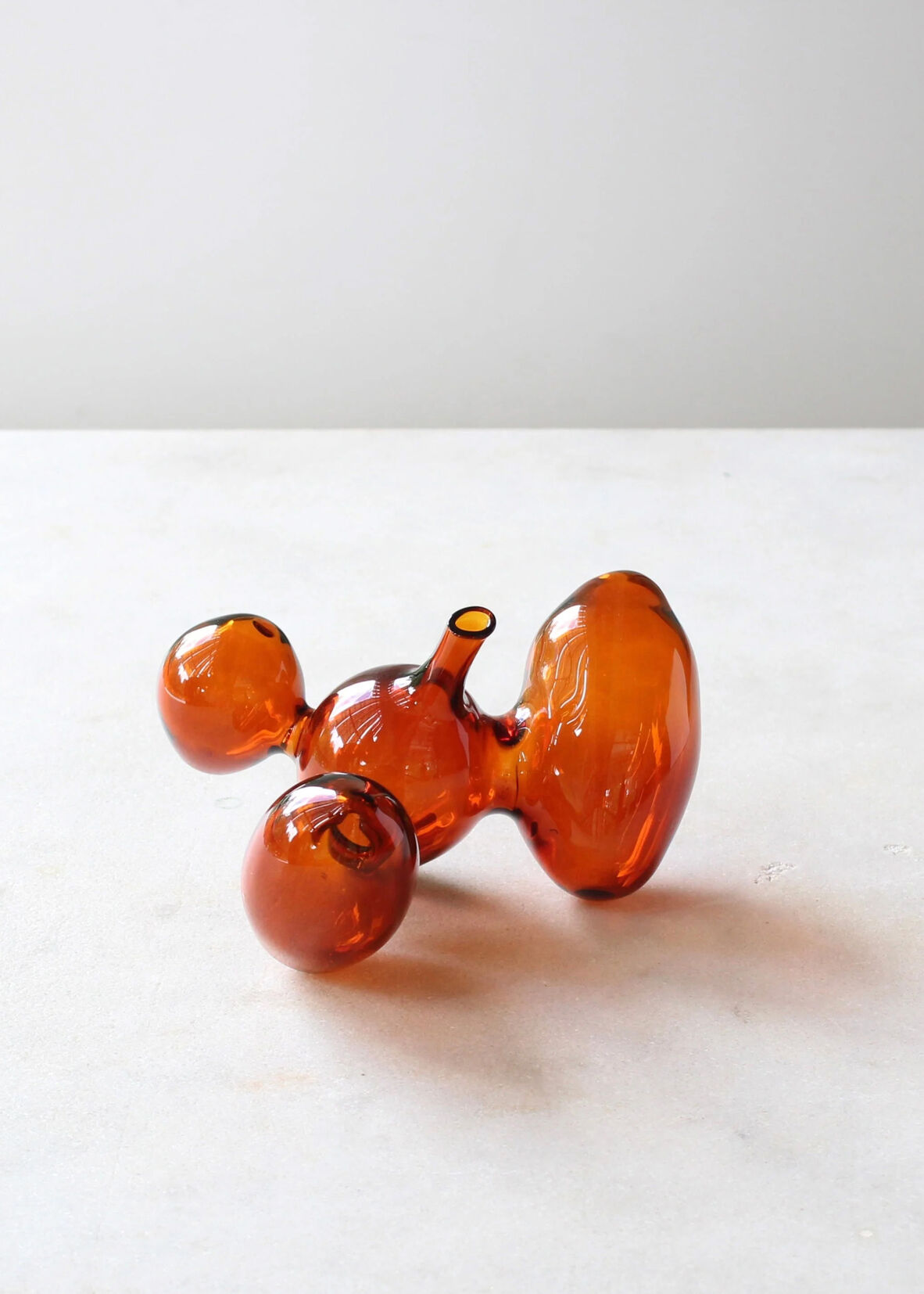 Orange vase in four roughly spherical organic shapes