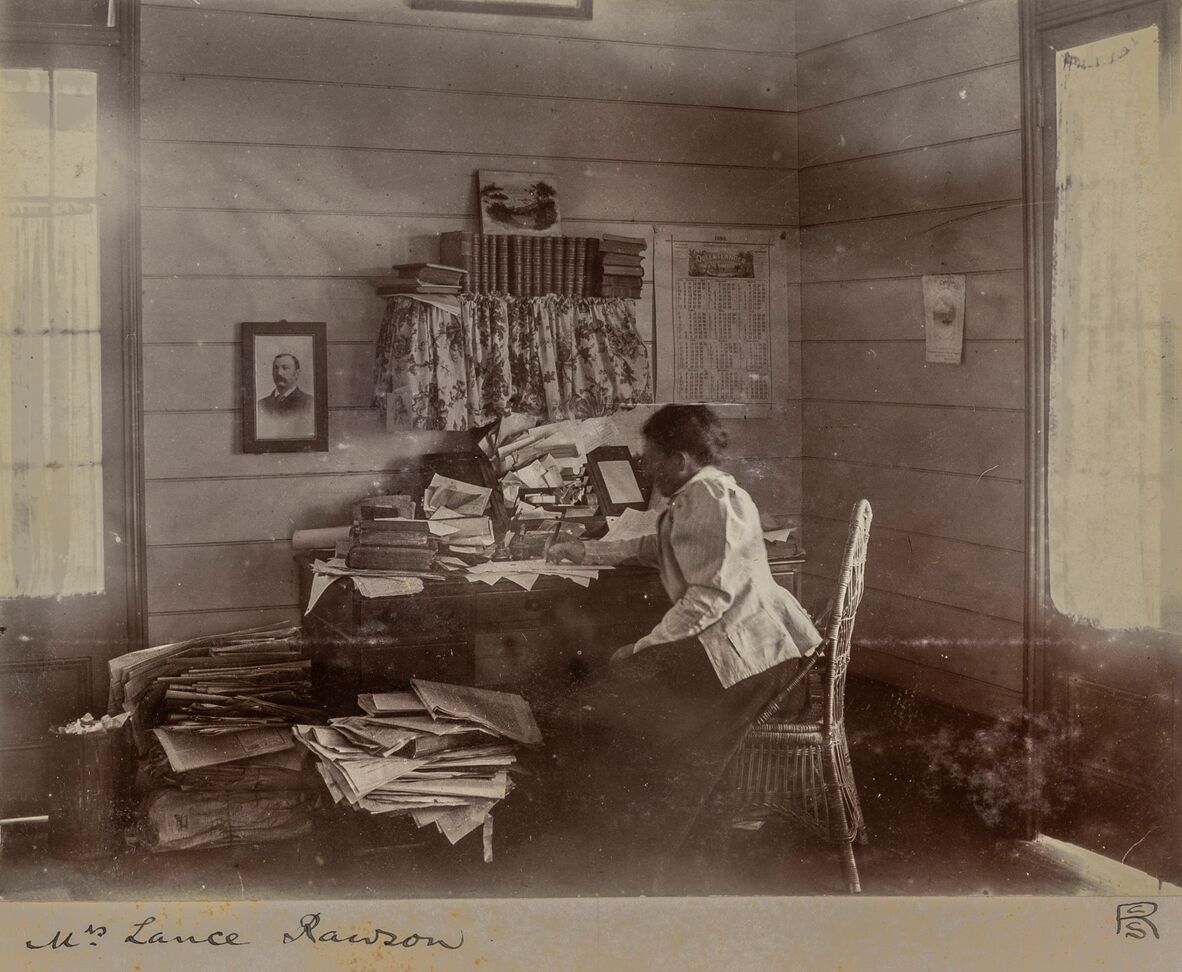 Wilhemina Rawson sitting at desk writing