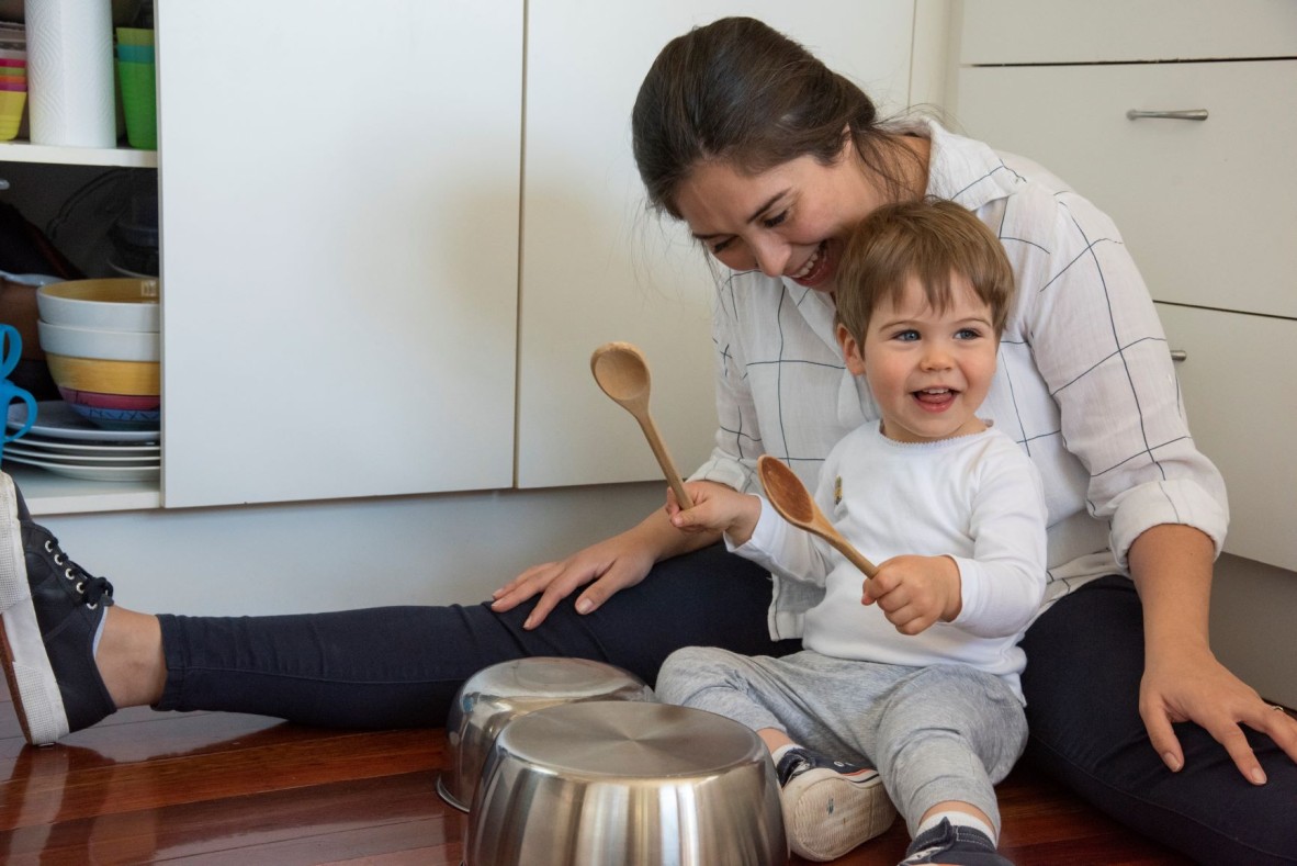 Mother and child playing in the kitchen with pots and pans