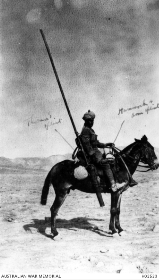 Man wearing turban sitting on a donkey in the desert with medical equipment, including a leg splint