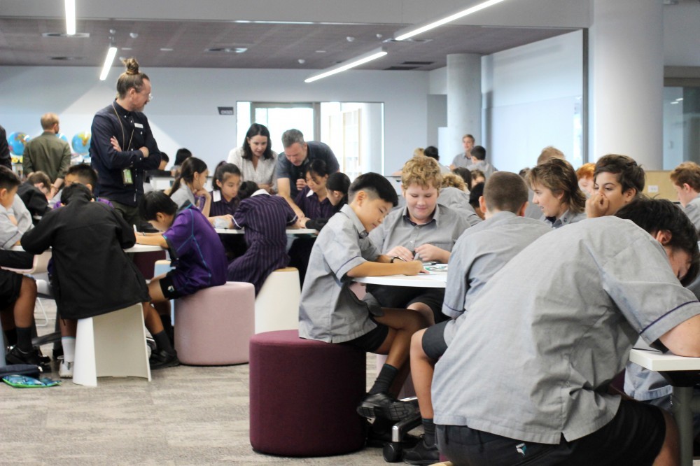 Students participating in school-based workshop with facilitators assisting their work