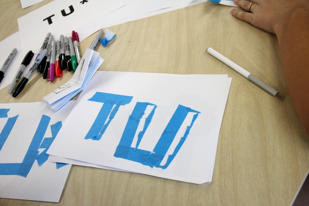 Student at desk with torn tape lettering experiment
