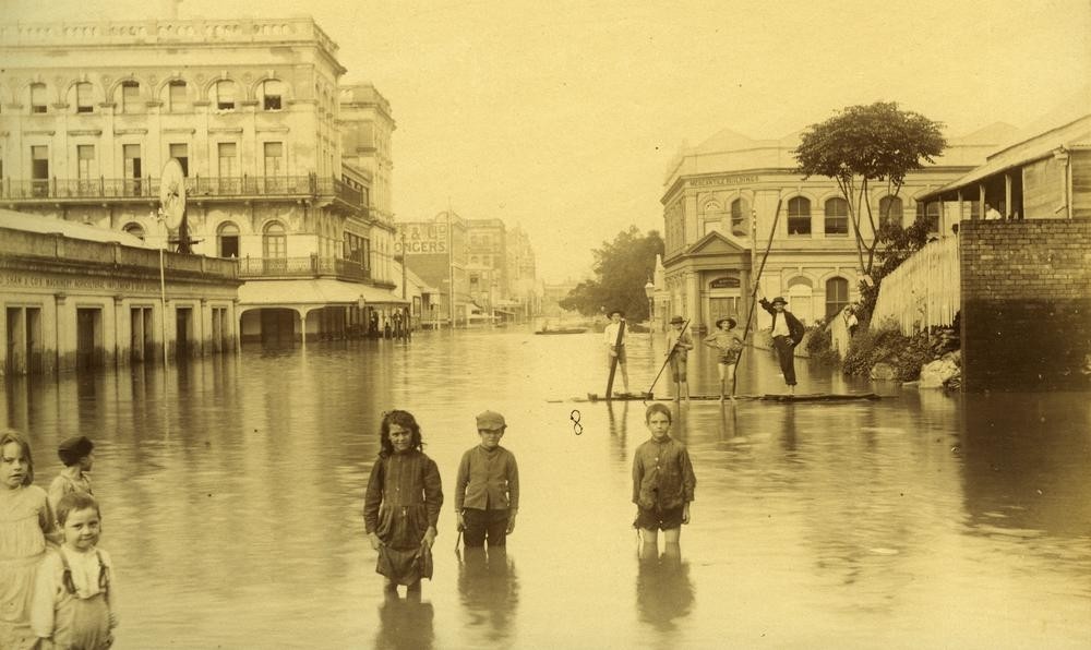 children stand in floodwaters