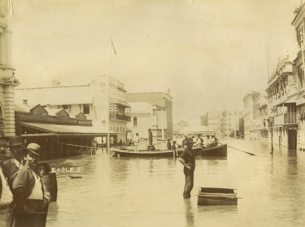 men stand in flood waters in Brisbane City