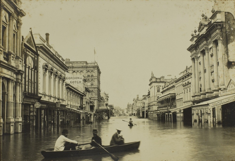 men row a canoe in a flooded street in 1893 Brisbane