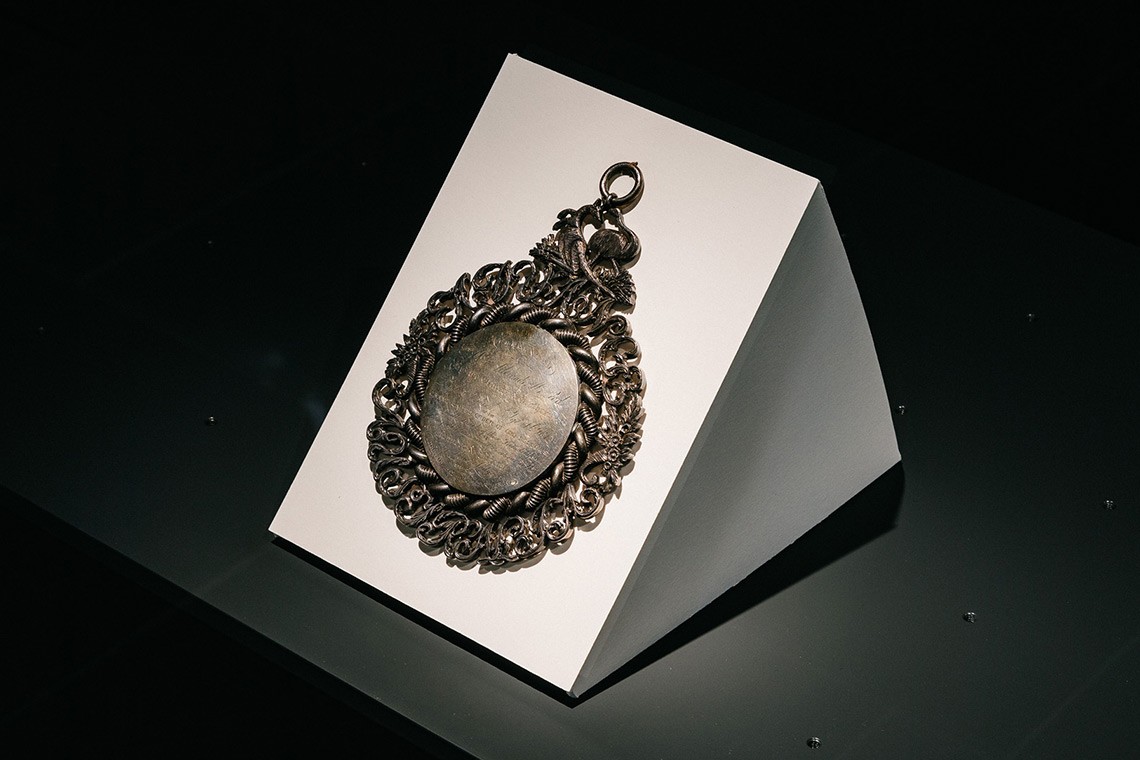 Circular polished silver medallion inscribed to founder, Alexander McLeod on 20th August 1850 to mark the first anniversary of the Odd Fellows' establishment. The medallion features intricate filigree design crowned with a kangaroo and emu.