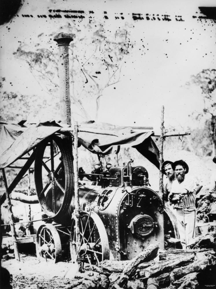 Prospectors next to a portable steam engine ca. 1870.