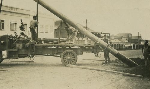 Worker erecting poles for electricity, 1937.