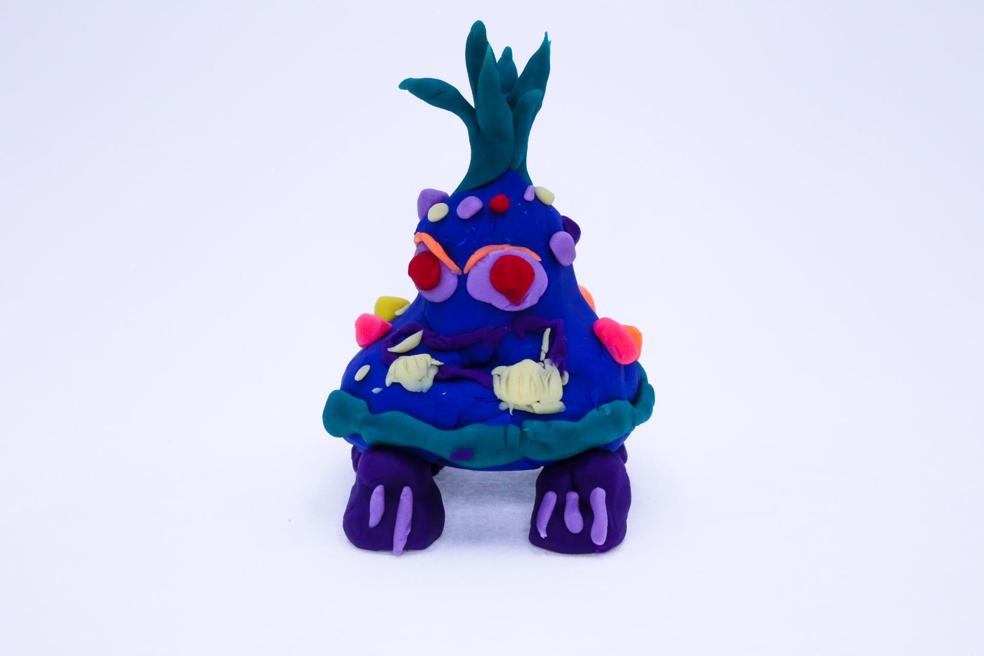 Blob Blob is a play-dough sculpture that features a grass head, angry eyes and a blob body.