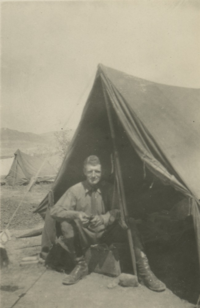 Man sitting at front of army tent in Middle East, 1914-1918